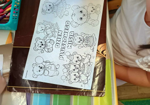 Dziecko podczas kolorowania kolorowanki tematycznej.